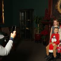 Alumni taking picture of her three kids with Santa Claus